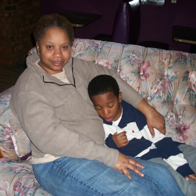 Boston's grandma sitting with him on a floral couch